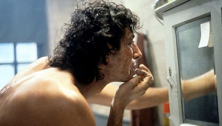 Jeff Goldblum looks at the mirror at the start of his transformation in the 1986 movie The Fly